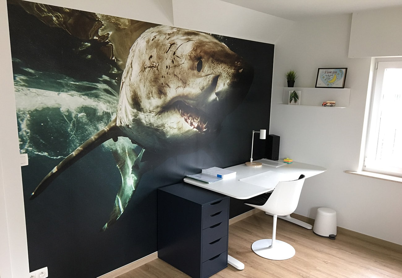 Kamer met indrukwekkende haai-muurdecoratie door In't Kleur bij het bureau.