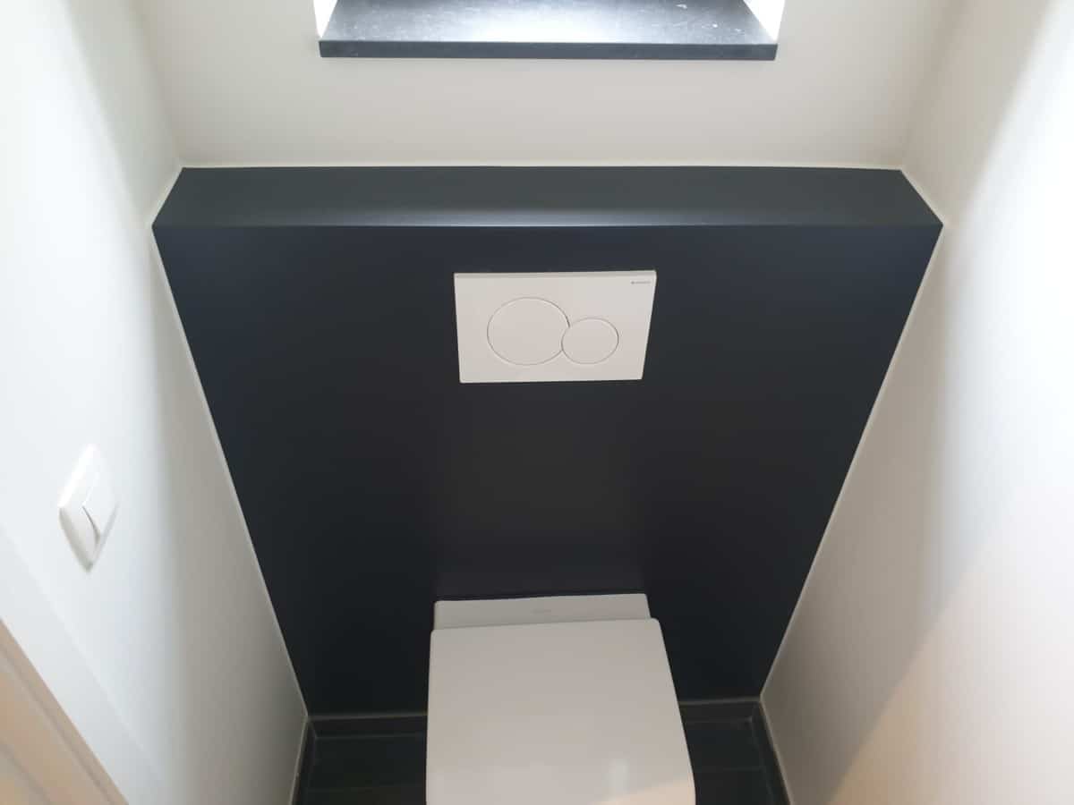 Toilet met zwarte accentmuur door In't Kleur.