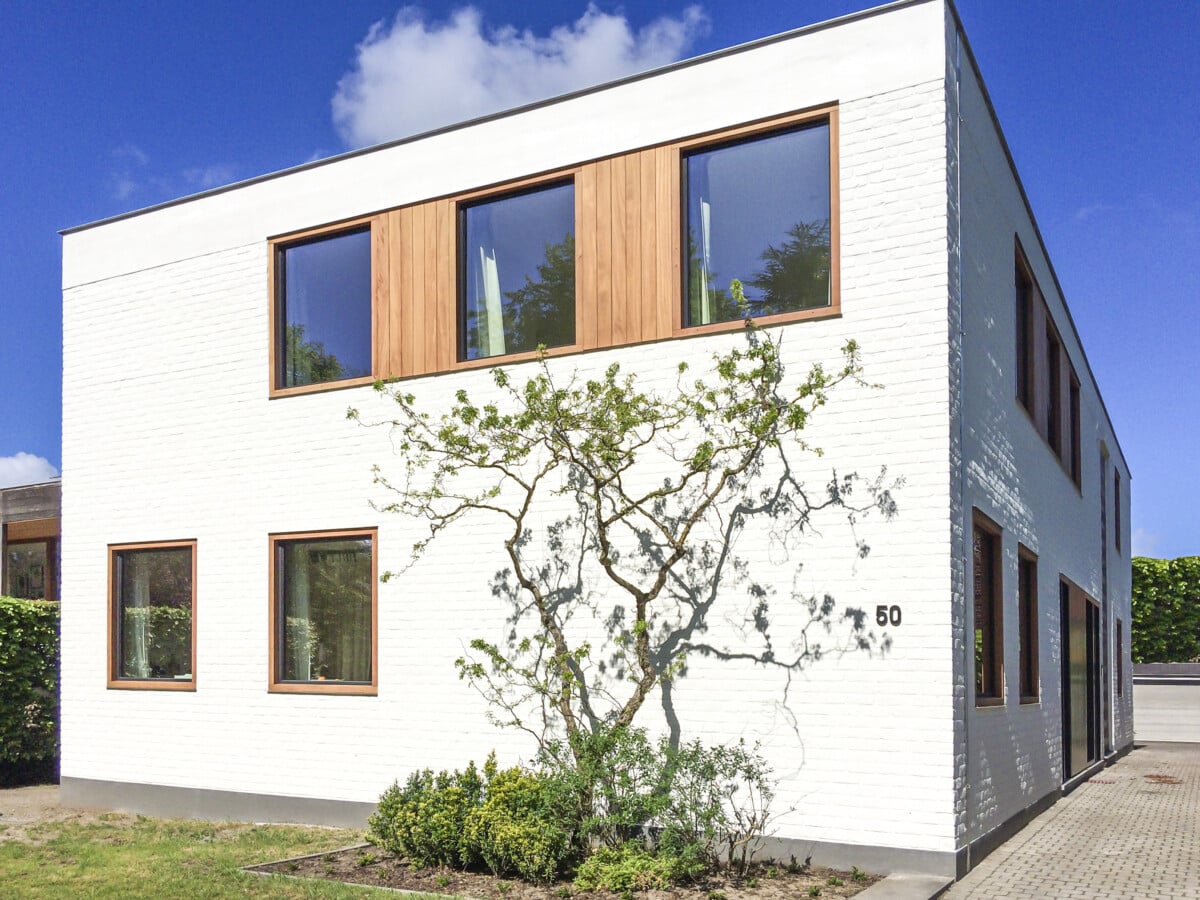 Gevel met veel ramen en witte bakstenen door In't Kleur.