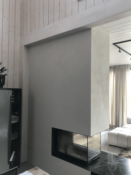 Strakke moderne haard met glazen panelen en witte afwerking.