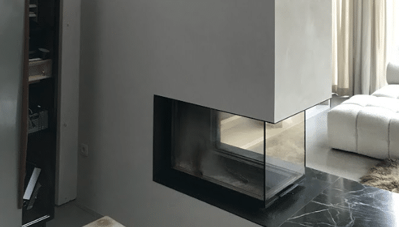 Zijaanzicht van moderne haard met glazen vuurplaats.