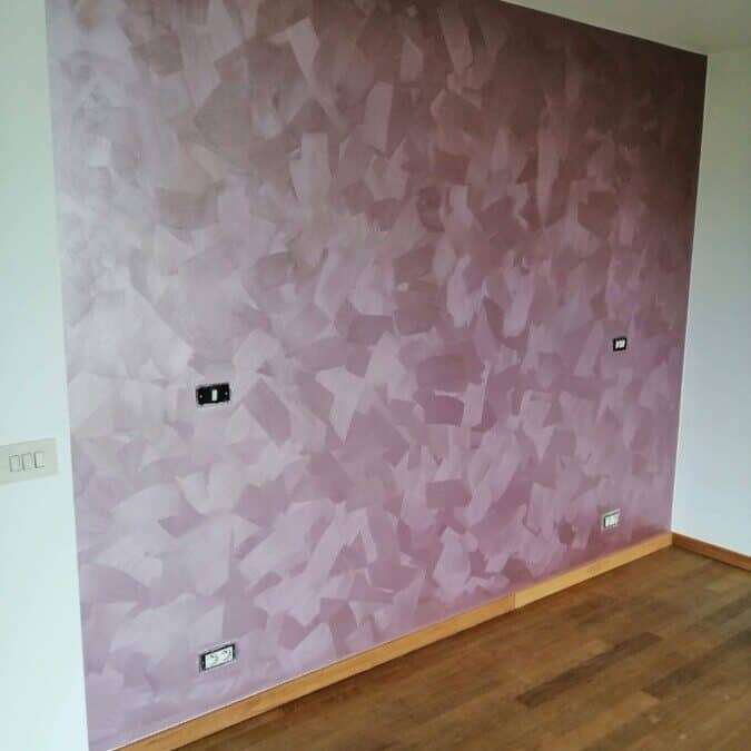 Structuurverf in roze tint op een muur, project in De Pinte.
