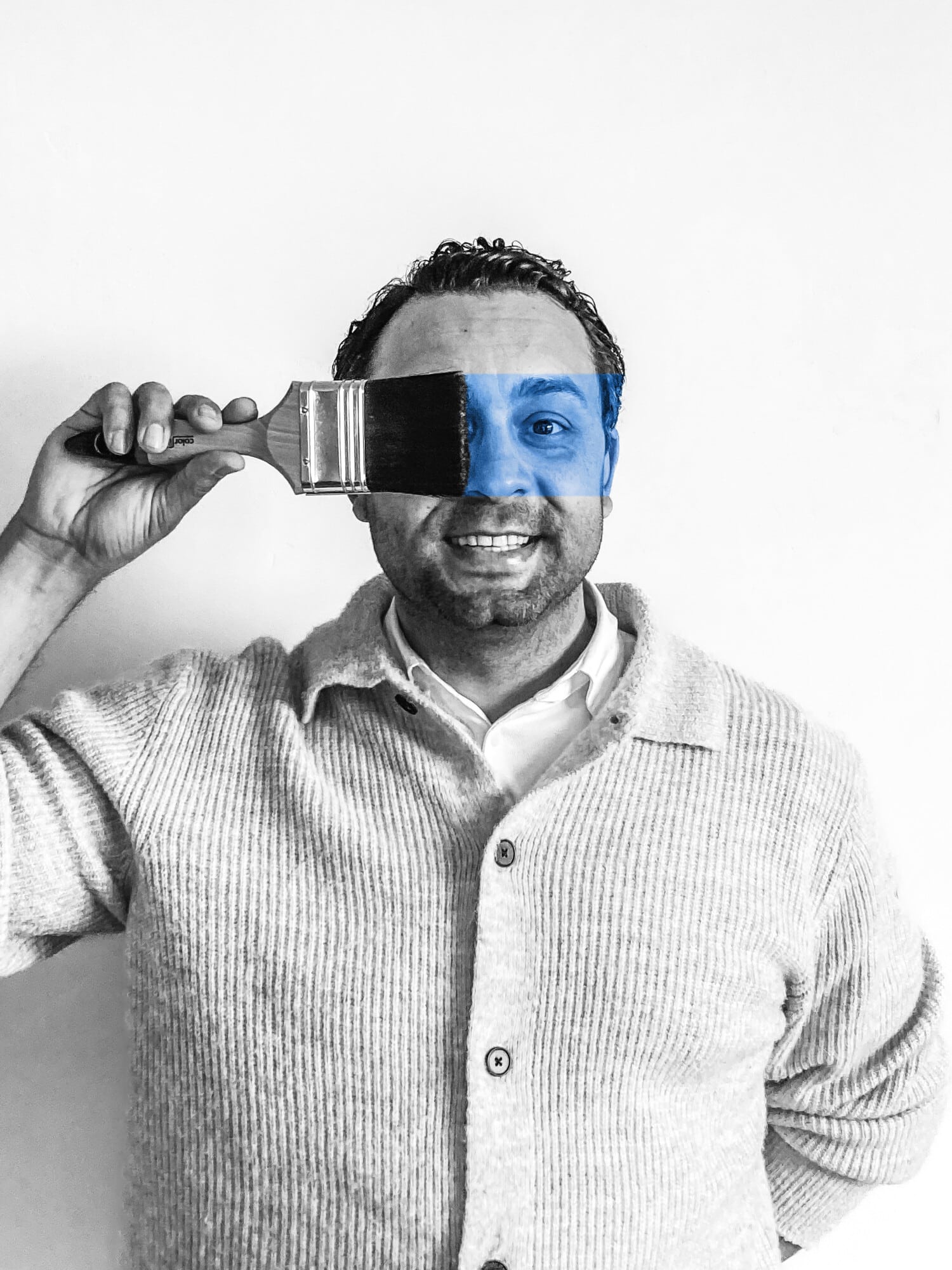 Man in gestreept overhemd houdt verfroller vast met blauwe verf op gezicht, symboliseert schilderwerk en kwaliteit